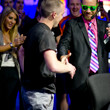 Trevor Pope is congratulated by WSOP Final Table announcer "Red Bull" Robbie.  Robbie wears Pope's sunglasses.