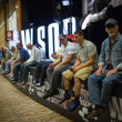 People hanging on the rail of the WSOP sign in the Pavilion Room