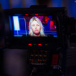 TV camera focused in on Jamila Von Perger while she waits for a call