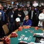 Philip Hilm (standing, left) pumps his fist as he flops a pair with A-K against Reagan Silber (right, standing in white), who is all in with Q-Q. Scotty Nguyen can be seen peeking over Silber's shoulder.