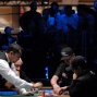 Alex Kravchenko takes his seat and chips after winning all-in with K,K