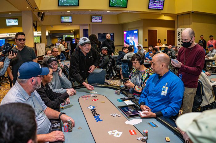 Jie Liu (center, standing) sees that his pocket queens are an underdog to Andrew Neeme’s pocket kings.